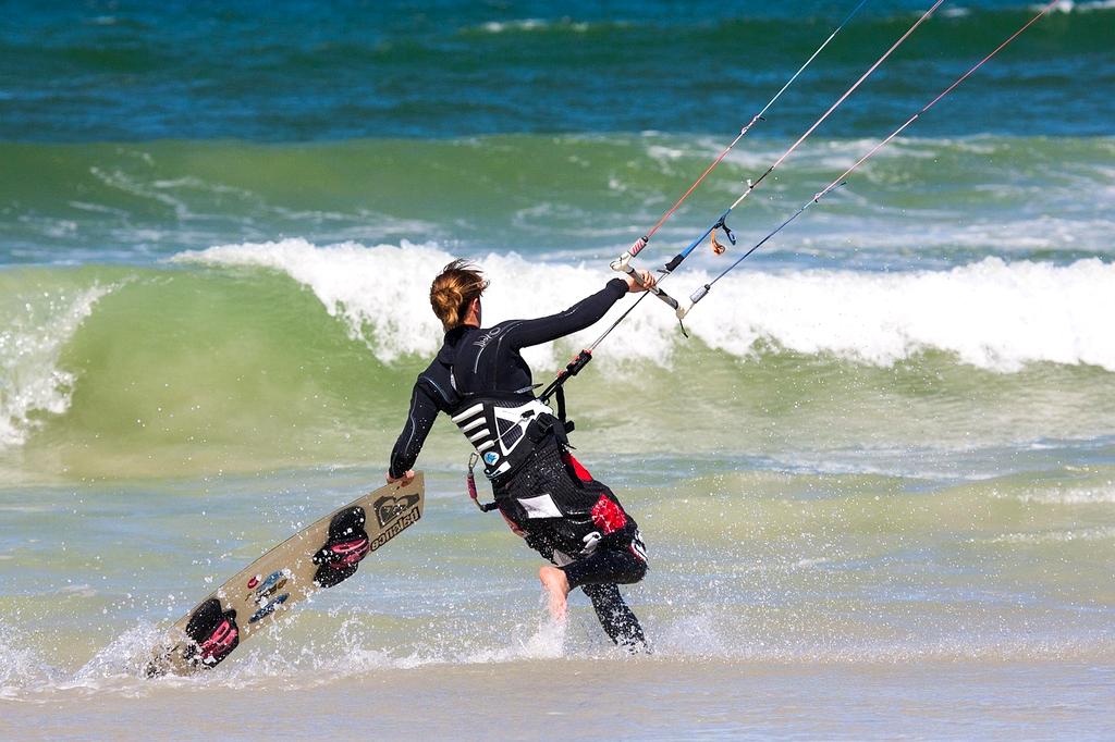 Children playing on a beach with colorful kites